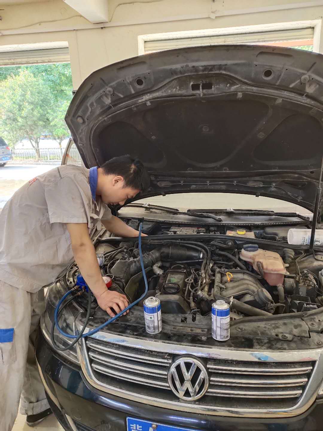 助手汽修师傅检查空调系统，加氟